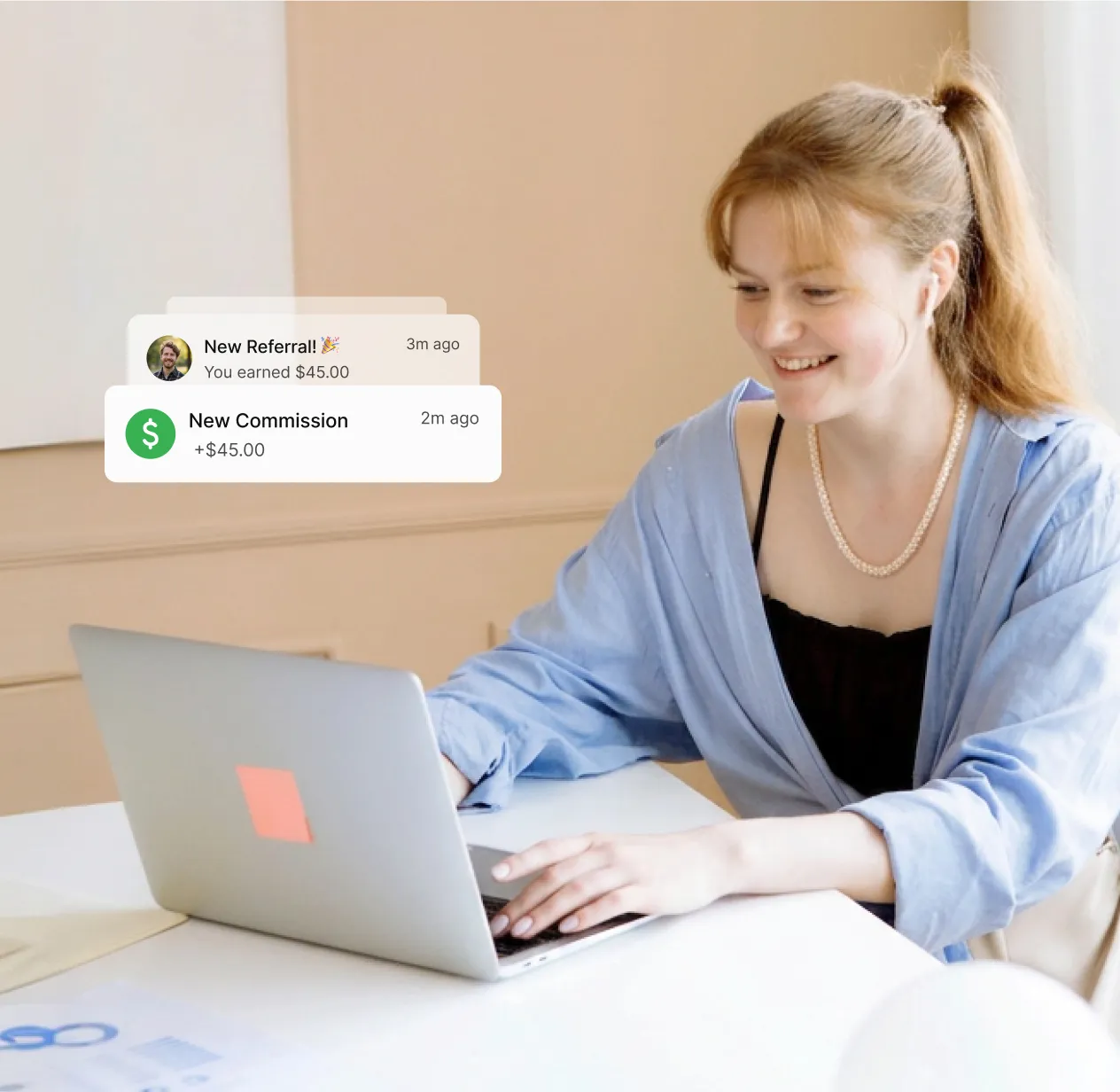 Woman sitting infront of her laptop, working and being happy after getting notifications of commission for referrals.